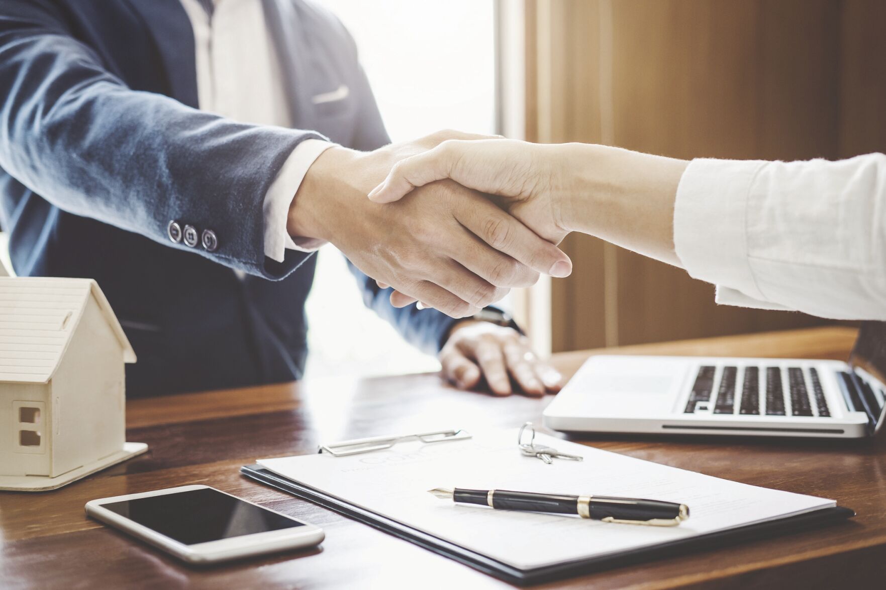 Real estate agent and customers shaking hands